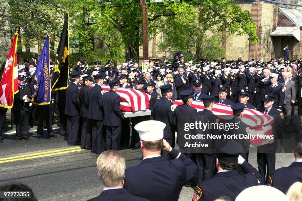 Firefighters salute as the caskets of Firefighters Michael Boyle and David Arce are carried into St. Brigid's Church in Westbury, L.I., for funeral...