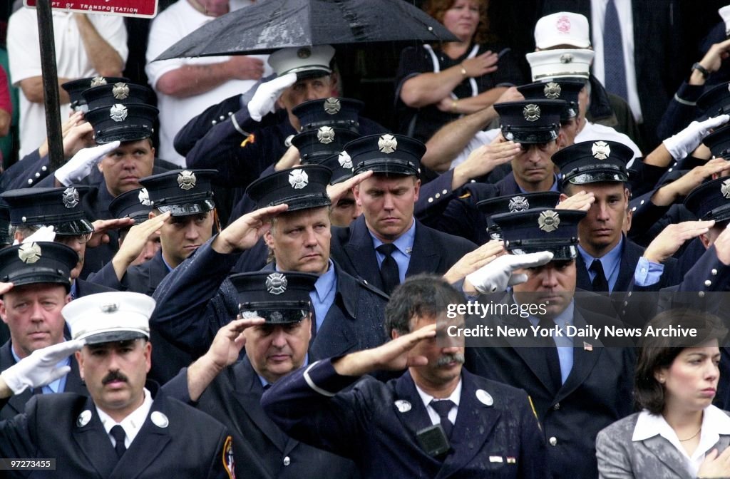 Firefighters salute during funeral services for Capt. Marty