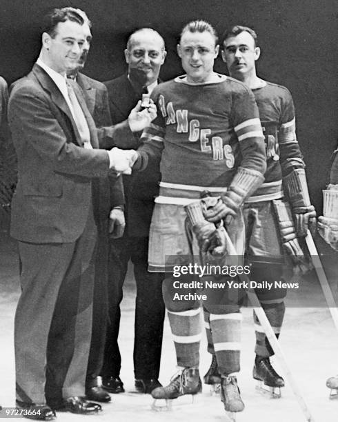 Congrats! From one Iron Man to another. Lou Gehrig, who's played 1,307 consecutive games with Yankees, presents ring to Murray Murdoch, who has taken...