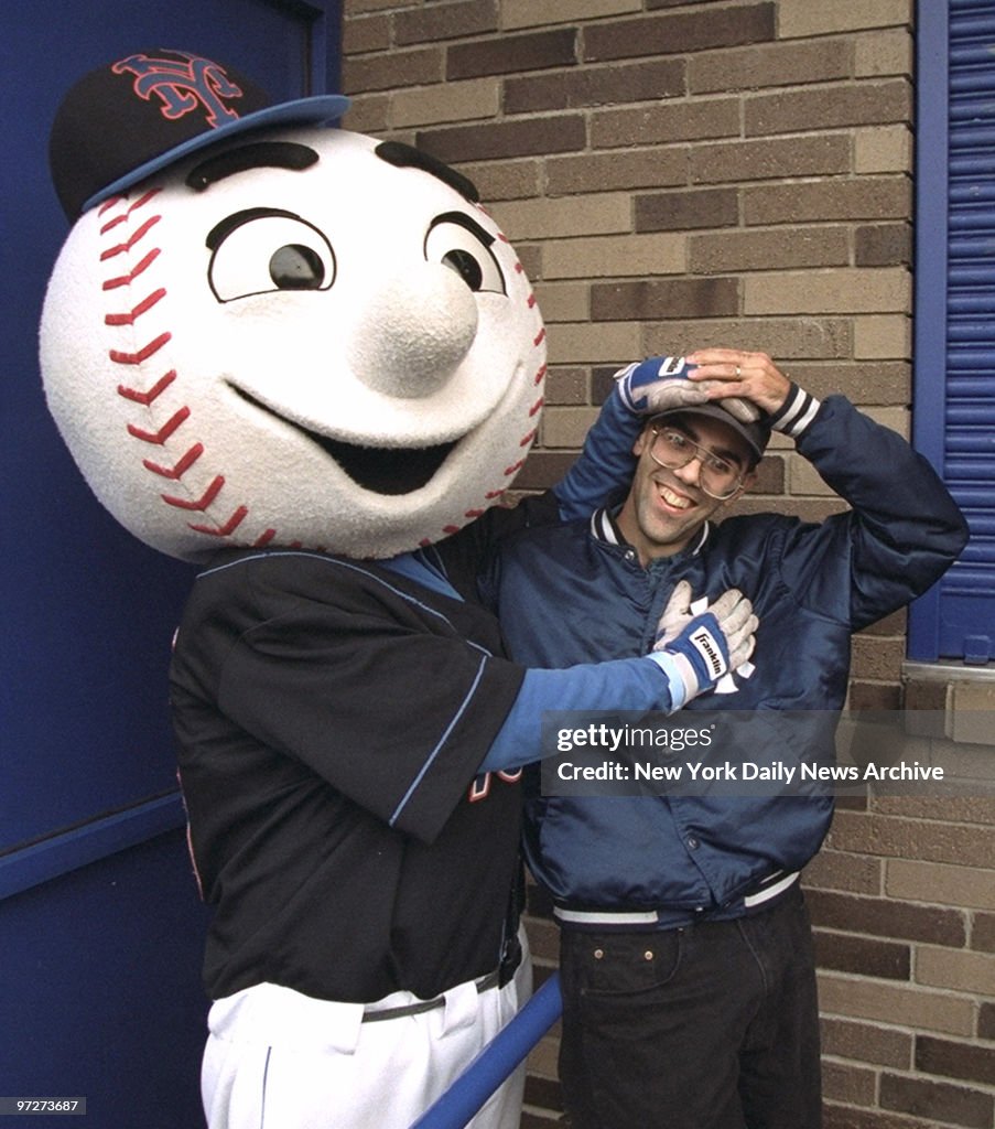 Mr Met tries to hide Yankee logos on Yankee fan Joe Garruba