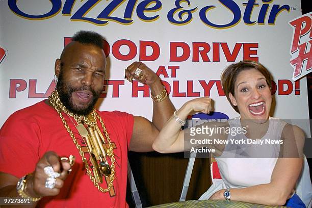Mr T. And Olympic gold medal gymnast Mary Lou Retton compare muscles at Planet Hollywood where they hosted a food drive benefit for Food for...