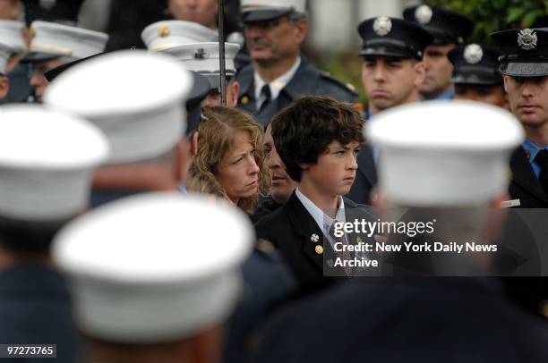 Firefighters surround fallen Fire Lt. Howard Carpluk's widow, Debra, and their 14-year-old son, Bradley, during his funeral at St. Mark's Episcopal...