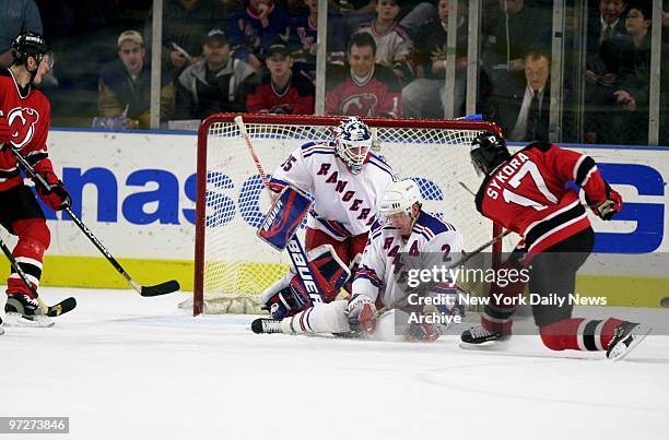 New York Rangers' Brian Leetch is hit with New Jersey Devils' Petr Sykora's stick as he tries to prevent a goal at Madison Square Garden. The game...