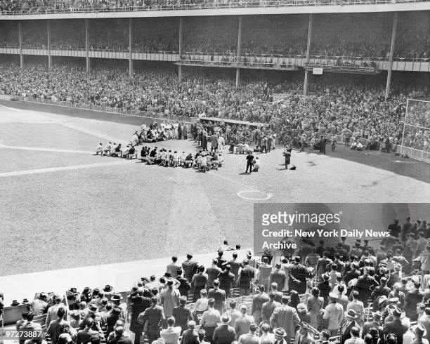 The crowd rises and roars as Babe Ruth steps to microphone near Yankee dugout. Players crouch around him as he thanks everyone for everything.,