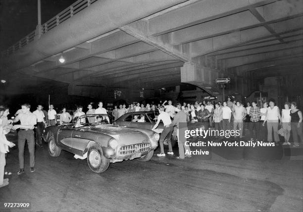 The crowd thrills with anticipation as two young drivers line up their cars as Corvette and hardtop, rev the souped-up engines and wait for start....