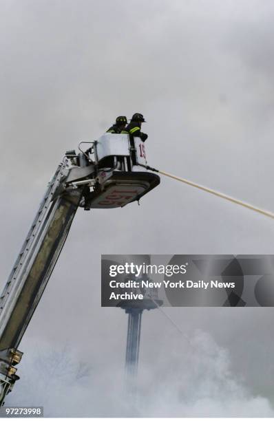 Firefighters use tower ladders to battle three-alarm blaze that raced through tire store on Merrick Blvd and 129th Ave. In Queens early Friday...