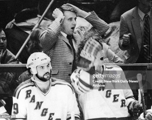 New York Rangers' coach Herb Brooks and players watcing game from bench.