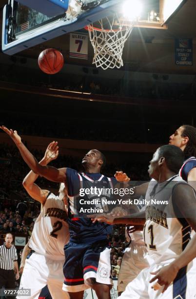 Connecticut Huskies' Emeka Okafor is surrounded by Pittsburgh Panthers as he reaches for the rebound during Big East championship game at Madison...