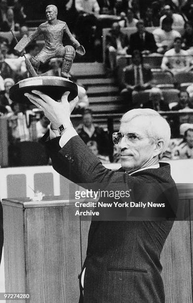New York Rangers' goalie Ed Giacomin holding trophy.