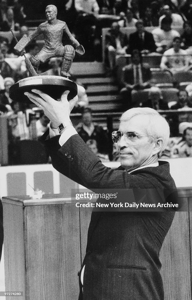 New York Rangers' goalie Ed Giacomin holding trophy.