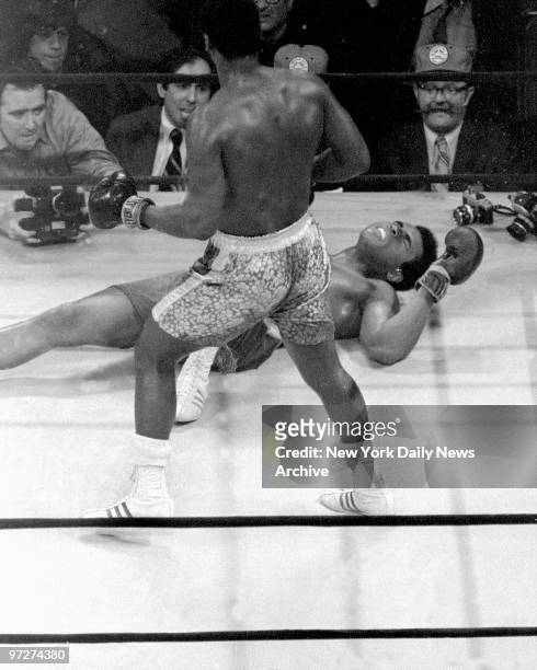 Muhammad Ali grimaces on the canvas after taking a left hook from Joe Frazier in the 15th round of their first fight, billed as the 'Fight of the...