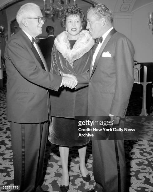Mrs. Ed Sullivan looks on as her husband shakes hands with Jack Flynn after accepted the Golden Friar.