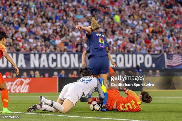 Women's National Team midfielder Lindsey Horan kicks at the ball as China PR goalkeeper Peng Shimeng covers the ball as China PR defender Wu Haiyan...