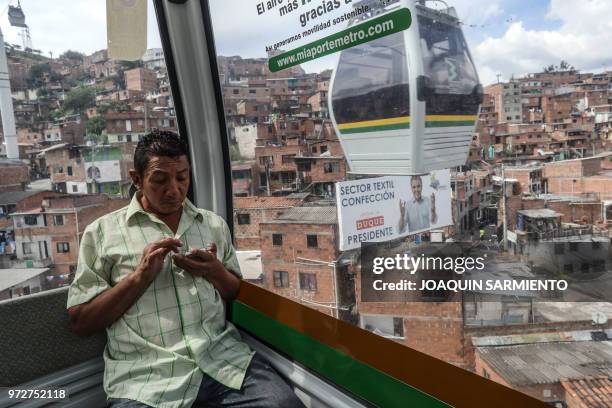 Metro cable car passes next to political advertising of Colombian presidential candidate Ivan Duque of the Centro Democratico party, in Medellin,...