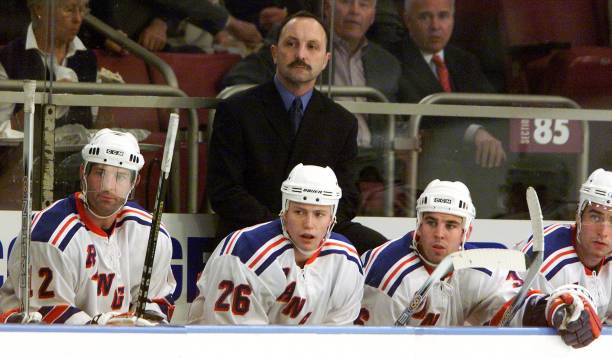 new-york-rangers-head-coach-bryan-trottier-watches-the-action-on-the-ice-along-with-players.jpg