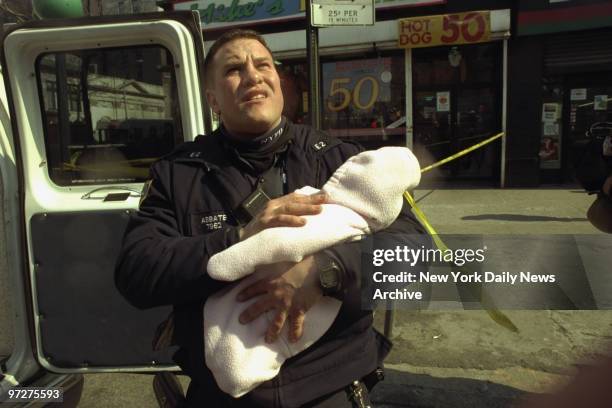 Scene of 7th alarm fire on Broadway near 108th Street Manhattan. NYPD E.S.S. #2 officer Greg Abbate holds infant taken from burning building at above...