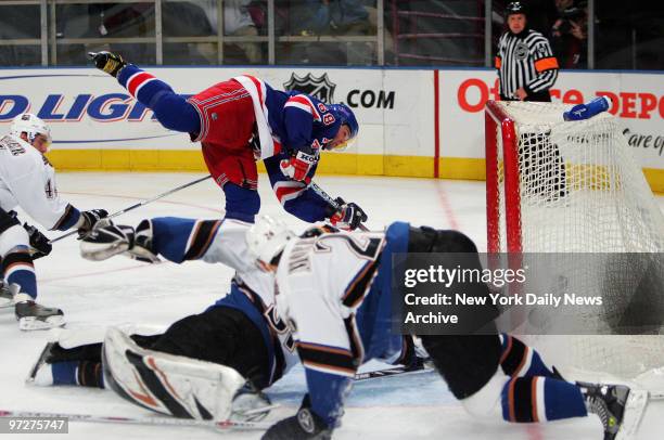 New York Rangers' Jaromir Jagr scores his 45th goal of the season to break a 4-4 tie as the Washington Capitals' Steve Eminger and Shaone Morrisonn...