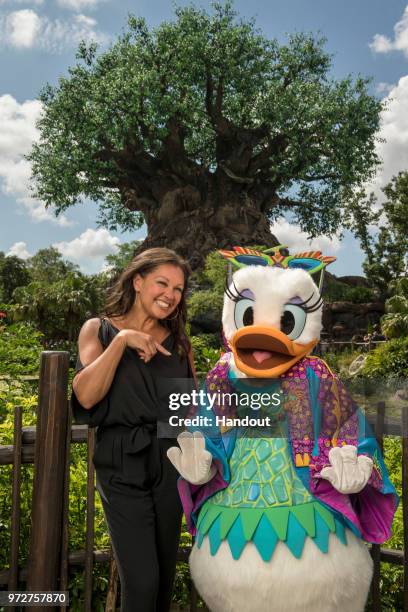 In this handout images provided by Walt Disney World Resort, Actress, singer and fashion designer Vanessa Williams poses with Daisy Duck, donning her...