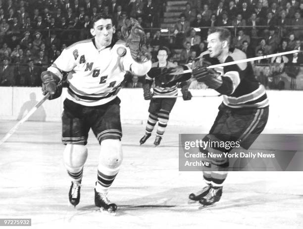 New York Rangers' Lou Fontinato fights for loose puck with Warren Godfrey during game against Boston Bruins.