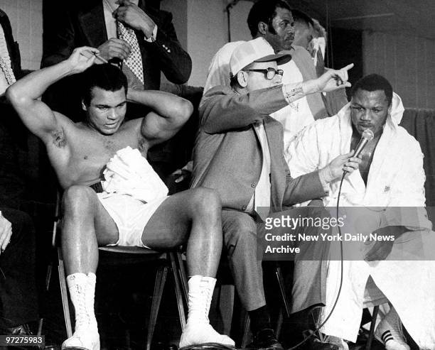 Muhammad Ali primps for the camera during a postfight interview as Joe Frazier states, "I want him again." Ali won the NABF heavyweight crrown in 12...