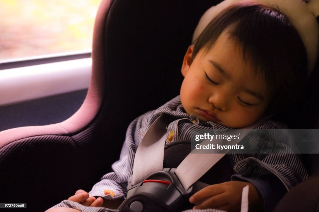 One boy asleep in the car