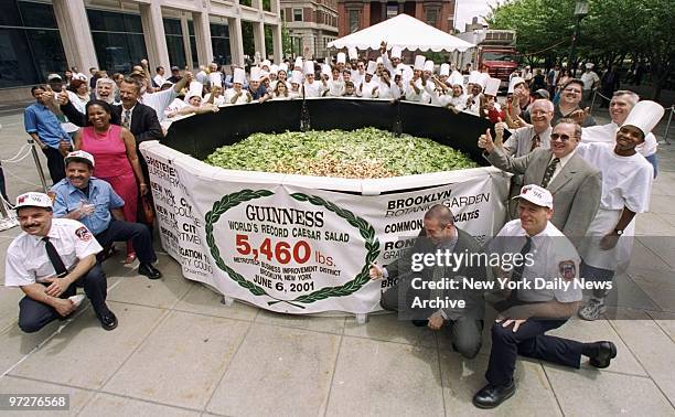 Local firefighters and students from New York City Technical College gather around their creation of the world's largest Caesar salad. The Guiness...