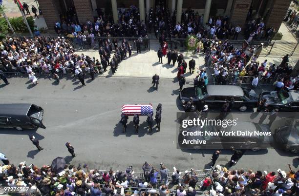 The flag-covered coffin of slain City Councilman James Davis is carried by an NYPD honor guard to a waiting hearse after his funeral at the Elim...