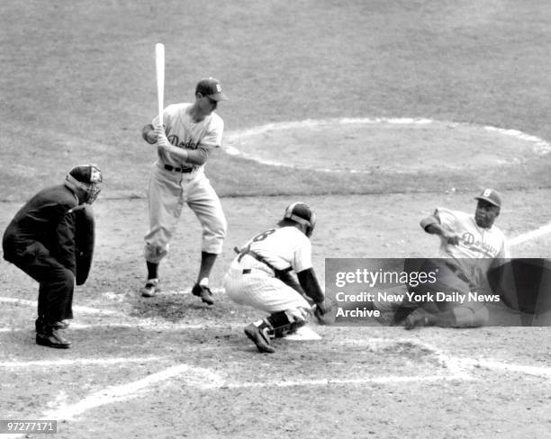 Jackie Robinson, Brooklyn Dodgers tries to steal home during World Series against the New York Yankees. Yankee Catcher Yogi Berra has the ball and...