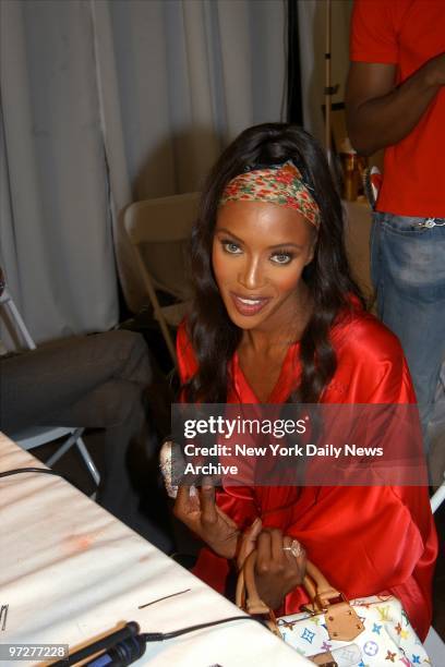 Naomi Campbell sports a jewelled cast on her finger, which was recently operated on, as she relaxes backstage just before the Victoria's Secret...