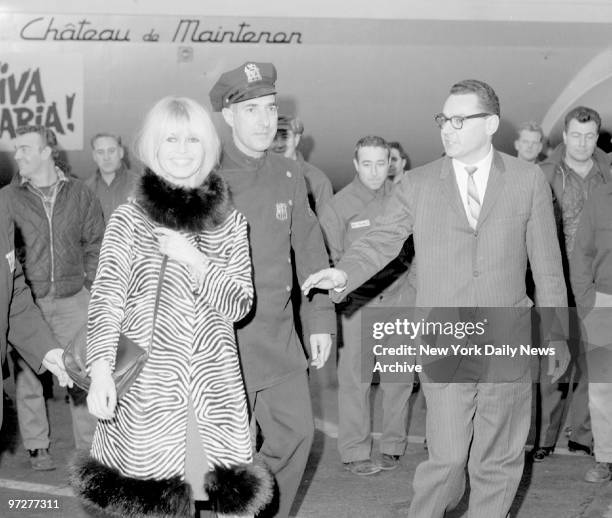 Brigitte Bardot arrives at Kennedy Airport looking chic in a zebra-striped coat.