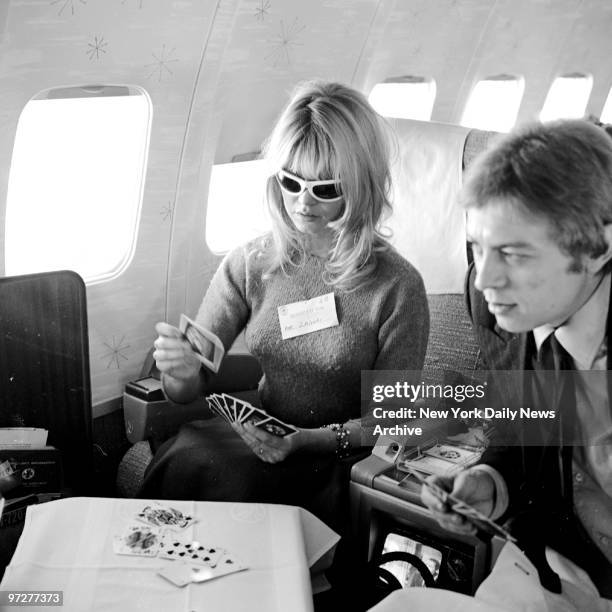 Brigitte Bardot relaxes with a game of cards en route to Hollywood.