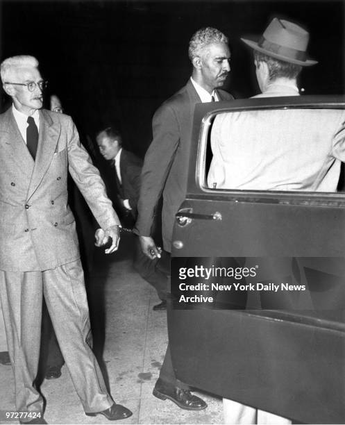 Mystery writer Dashiell Hammett is handcuffed to fellow Civil Rights Congress representative W. Alphaeus Hunton, as he approaches car at Federal...