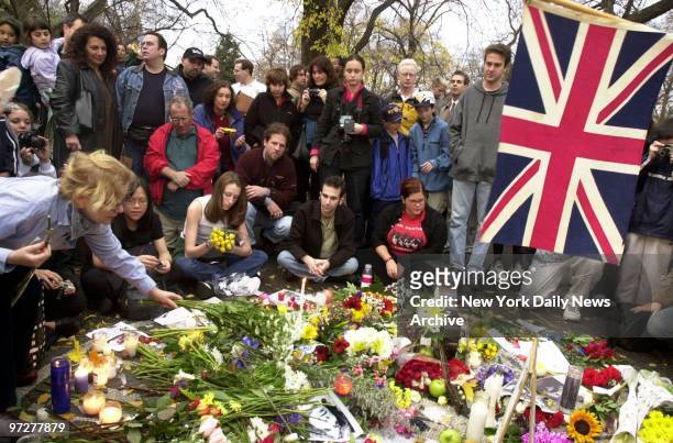 British flag flies as mourners place flowers and candles on a makeshift shrine in memory of George Harrison at Strawberry Fields in Central Park. The...