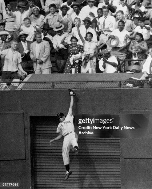 The Giants' amazing Willie Mays amazes centerfield fans with leaping, one-handed catch of Duke Snider's long drive to exit gate in seventh inning....