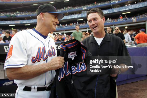 British Open golf champ Todd Hamilton is presented with a warmup jacket by New York Mets' manager Art Howe before a game between the Mets and Florida...