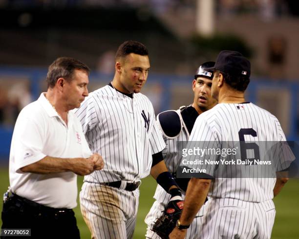 New York Yankee Derek Jeter with bruised and bloodied face head back to dugout after making run-saving catch on popup by Boston's Trot Nixon in 12th...