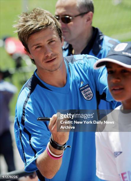 British soccer star David Beckham of the England National Team signs autographs for fans during practice at Giants Stadium for a May 31 match against...