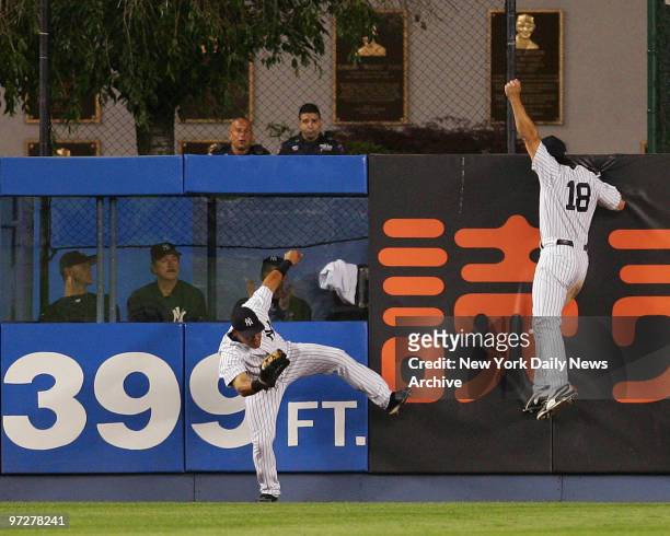 New York Yankee Melky Cabrera scales fence for spectacular catch to rob Manny Ramirez of game-tying homer in eighth, which has Johnny Damon all...