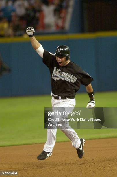 Florida Marlins' Alex Gonzalez raises his fist in the air as he rounds the bases after hitting a solo homer in the 11th inning to win Game 4 of the...