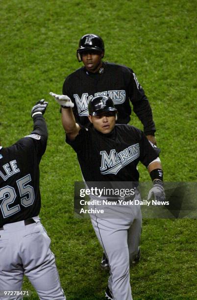 Florida Marlins' catcher Ivan Rodriguez is congratulated by teammates after hitting a sacrifice fly to score outfielder Juan Pierre in the first...