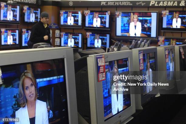 The image of "CBS Evening News" anchor Katie Couric is projected on television sets at a P.C. Richard & Son store at 2372 Broadway in Manhattan as...