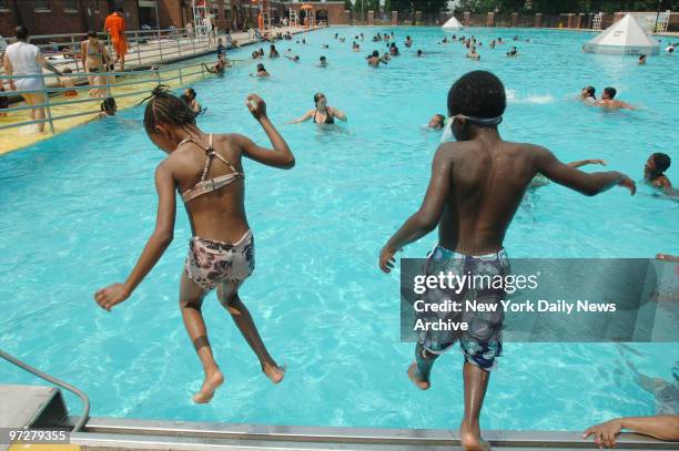 Cousins Daysiah Smith and Jahmel Binns take a leap in the water together at Sol Goldman pool in Red Hook on a hot Friday afternoon.