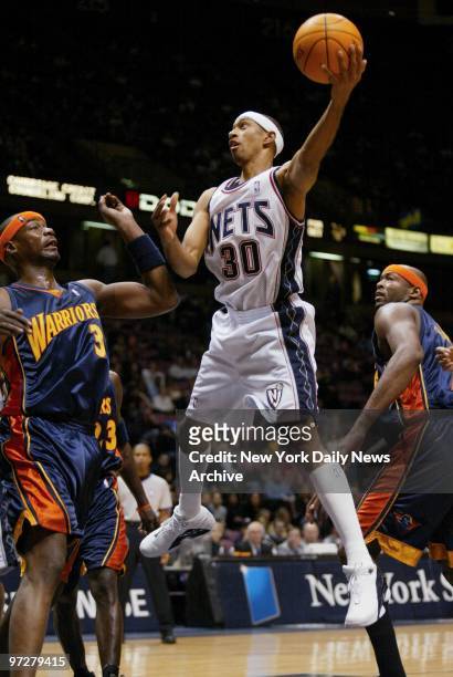 New Jersey Nets' Kerry Kittles shoots the ball over Golden State Warriors' Jason Richardson during a game at Continental Airlines Arena. The Nets...