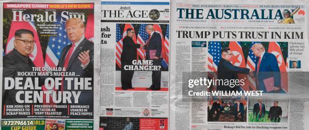 This photo illustration taken in Melbourne on June 13, 2018 shows Australian morning newspapers with front page coverage of the June 12, 2018...