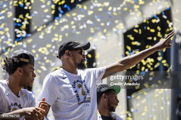 Kevin Durant of the Golden State Warriors acknowledges the crowd as he passes by atop a double decker bus during the Golden State Warriors NBA...
