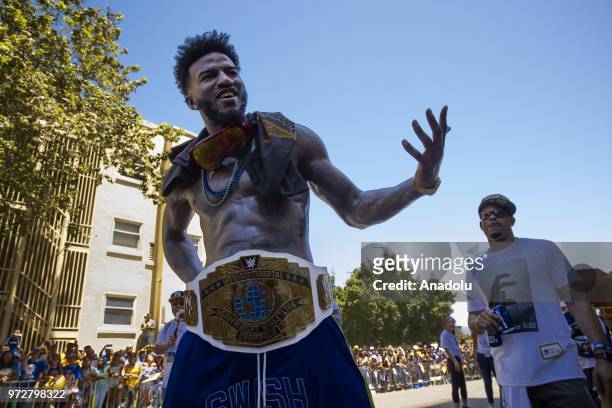 Jordan Bell of the Golden State Warriors wears a wrestling championship belt he received from a fan, as he interacts with the crowd during the Golden...