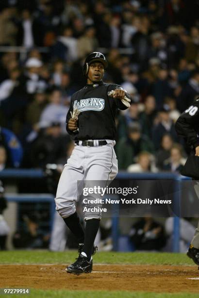 Florida Marlins' outfielder Juan Pierre scores on a sacrifice fly by catcher Ivan Rodriguez in the first inning of Game 1 of the World Series against...