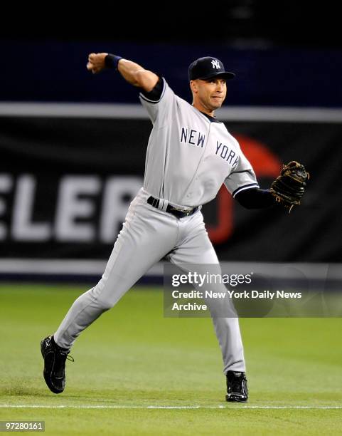 New York Yankees against the Minnesota Twins, Derek Jeter fields infield single by Denard Span in eighth inning, then throws as he sees Twins' Nick...