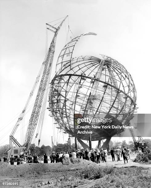 Crane eases last segment of the Unisphere into place to complete structure which will serve as symbol of the World's Fair in Flushing Meadow....