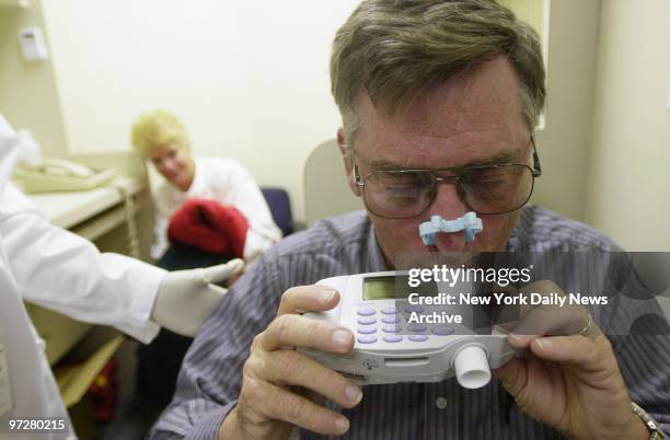 Crane operator Stephen Nolan takes a breathing test to check lung function as his wife, Peg, watches at a medical screening clinic for World Trade...